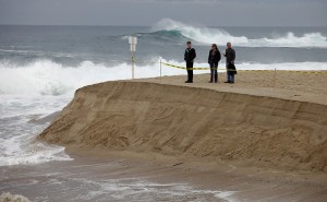 People watch as the Carmel River flows to the ocean at Carmel River State Beach on Monday, January 11, 2016.  County crews worked with equipment on Sunday to start the breach through the sand bar at the southern channel.  The river broke through on its own sometime Sunday night.  (Vern Fisher - Monterey Herald)